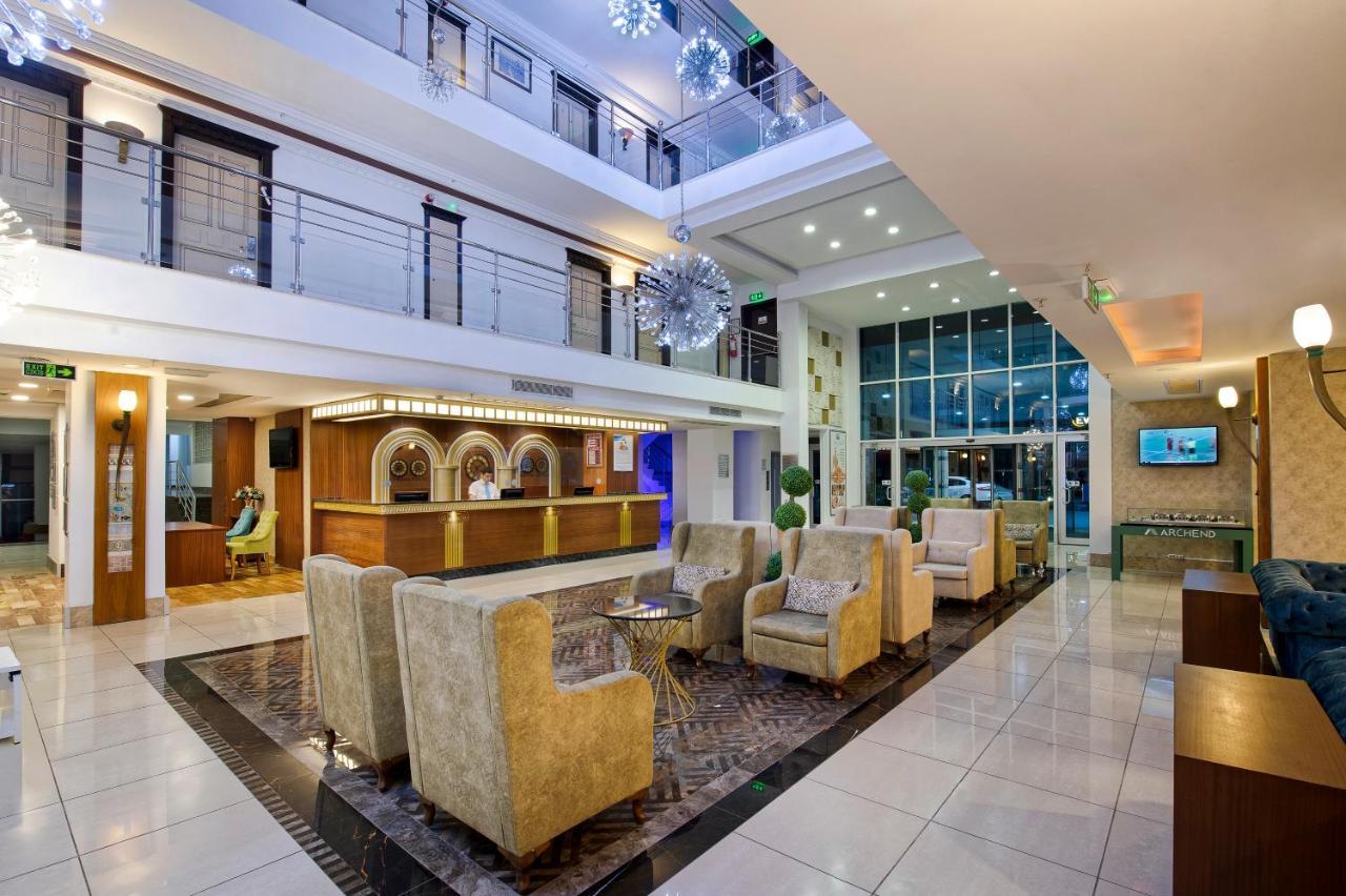 אנטליה Sealife Family Resort Hotel מראה חיצוני תמונה The image depicts a modern hotel lobby. The space features an open design with multiple levels visible. It has a bright and welcoming atmosphere, highlighted by large windows that allow natural light to flood the area. 

The seating arrangement inclu