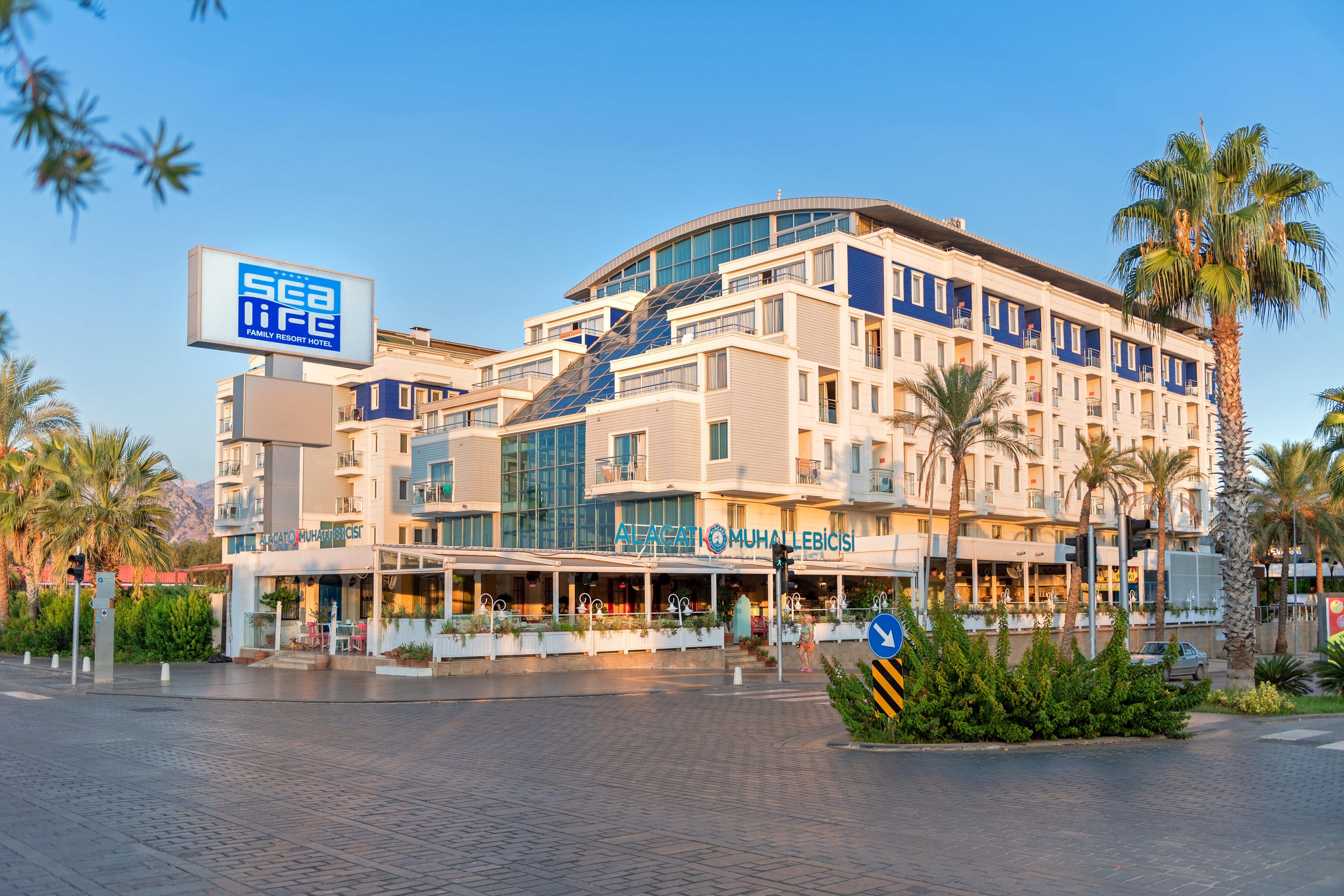 אנטליה Sealife Family Resort Hotel מראה חיצוני תמונה The photo shows a modern building with a contemporary architectural design, featuring multiple levels and large glass windows. There is a sign that reads "sea life" prominently displayed on the left. The building appears to house a restaurant or café